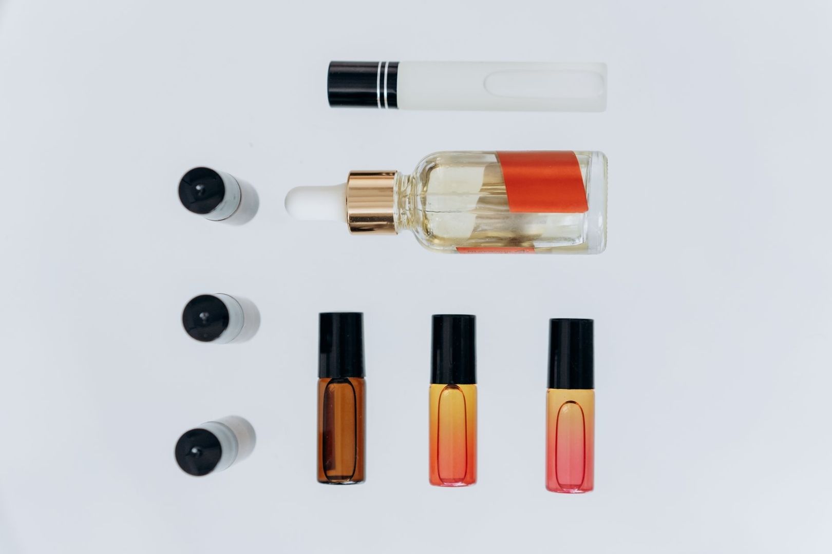 Geöffnete Flasche und mehrere kleine Fläschchen mit verschiedenfarbigem Öl